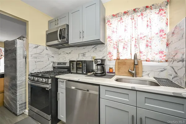 a kitchen with stainless steel appliances granite countertop white cabinets and black appliances