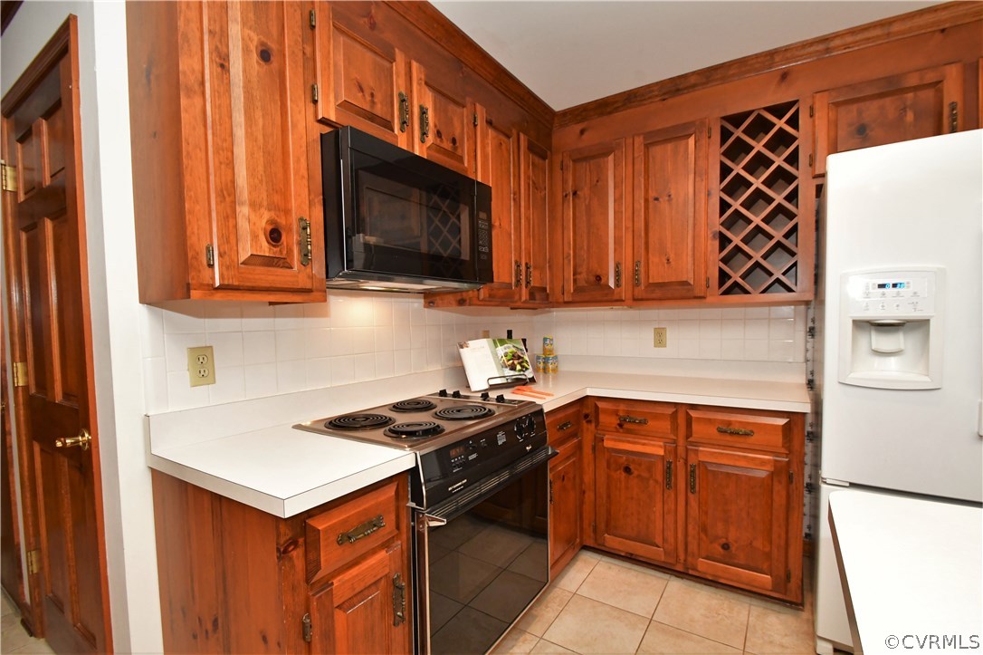 11101 Erin Road Chester, VA 23831 - Photo 13 of 46 a kitchen with stainless steel appliances a stove a microwave and wooden cabinets