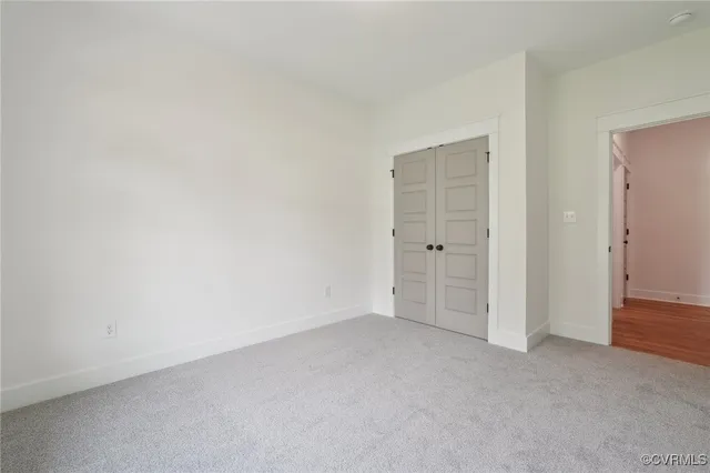 an empty room with wooden floor chandelier fan and windows