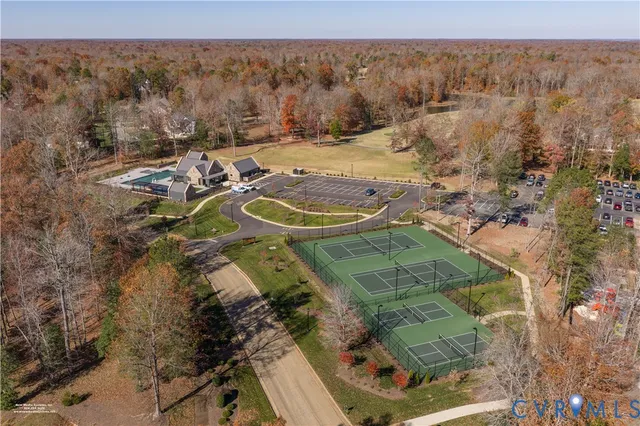a view of a tennis ground with large trees