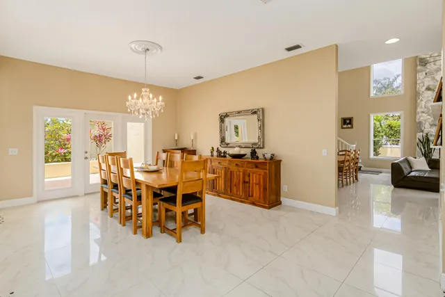 a living room with furniture floor to ceiling window and a flat screen tv