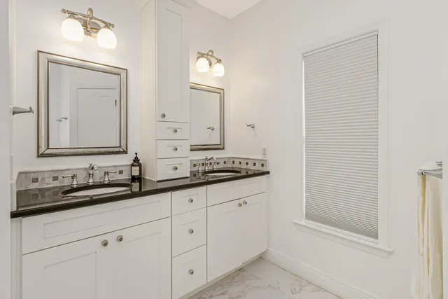 a bathroom with a double vanity sink mirror double and bathtub