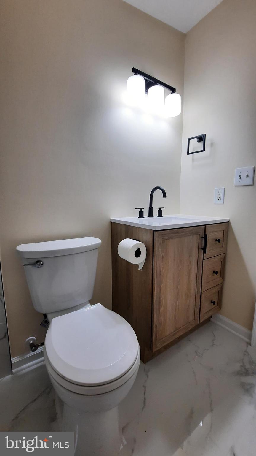 21051 Seigen Lane Richardsville, VA 22736 - Photo 21 of 42 a white toilet sitting next to a bathroom sink and vanity