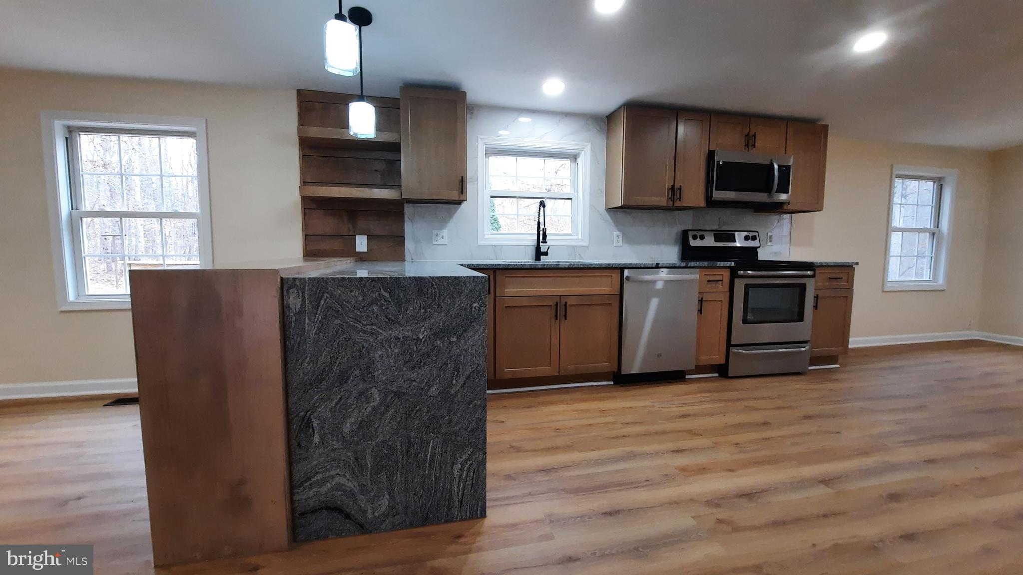 21051 Seigen Lane Richardsville, VA 22736 - Photo 7 of 42 a kitchen with stainless steel appliances granite countertop a stove top oven a sink dishwasher and a microwave oven on the wooden floor