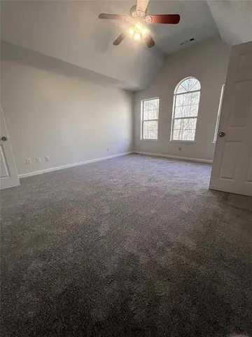 en empty room with windows and chandelier fan