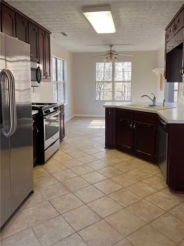 a kitchen with stainless steel appliances granite countertop a stove a sink and a refrigerator