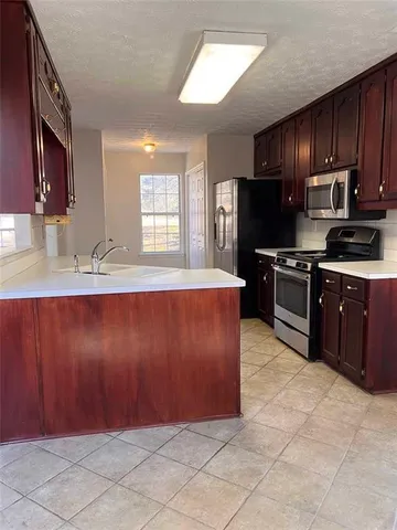 a kitchen with granite countertop a stove cabinets and refrigerator