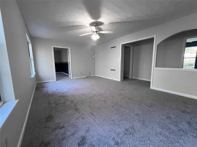 a view of a livingroom with a ceiling fan and window