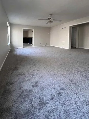 a view of an empty room with a fireplace and a window