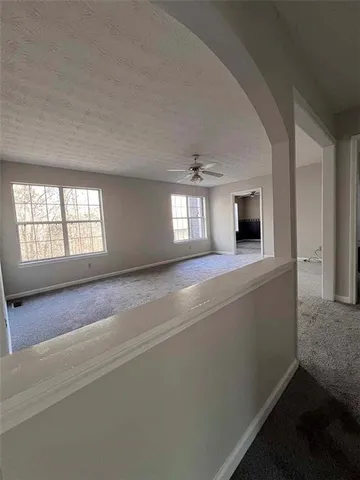 a view of an empty room with window and fireplace