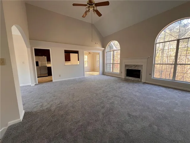 an empty room with windows and fireplace