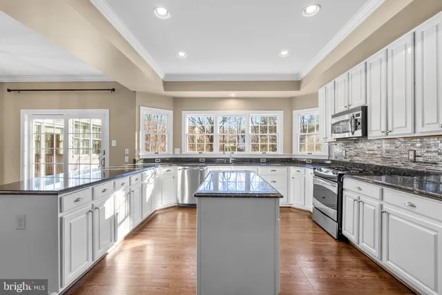 a kitchen with stainless steel appliances granite countertop a stove a sink dishwasher and a refrigerator