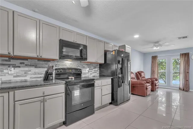 a kitchen with cabinets stainless steel appliances and a window