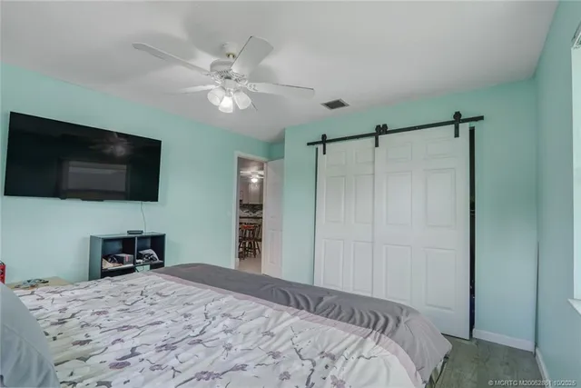 a bedroom with a bed and a flat tv screen on dresser