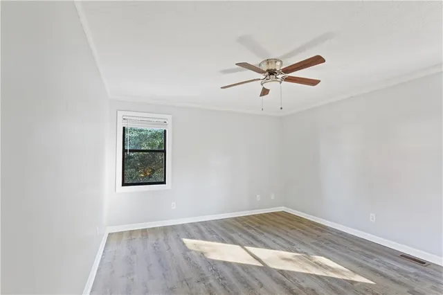 an empty room with a window and a ceiling fan