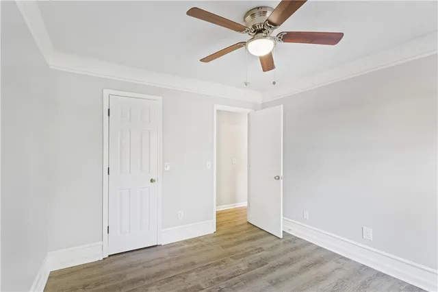 an empty room with wooden floor ceiling fan and a ceiling fan