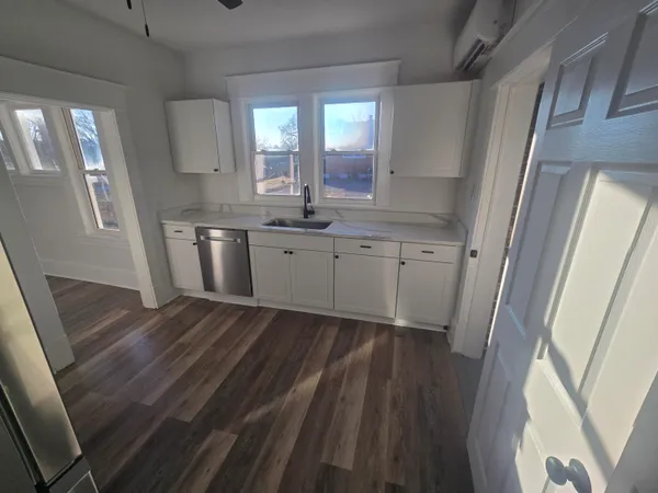 a room with granite countertop a sink a window and wooden floor