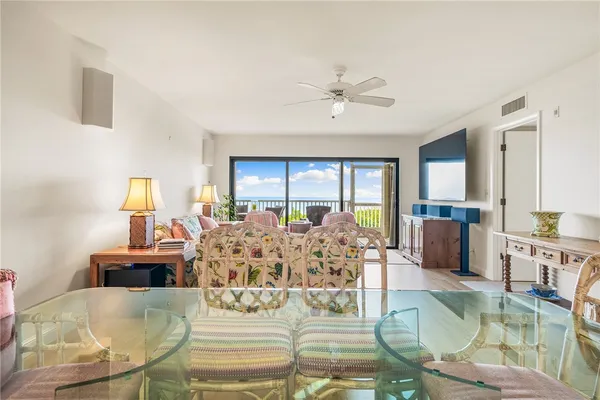 a living room with furniture large window and wooden floor