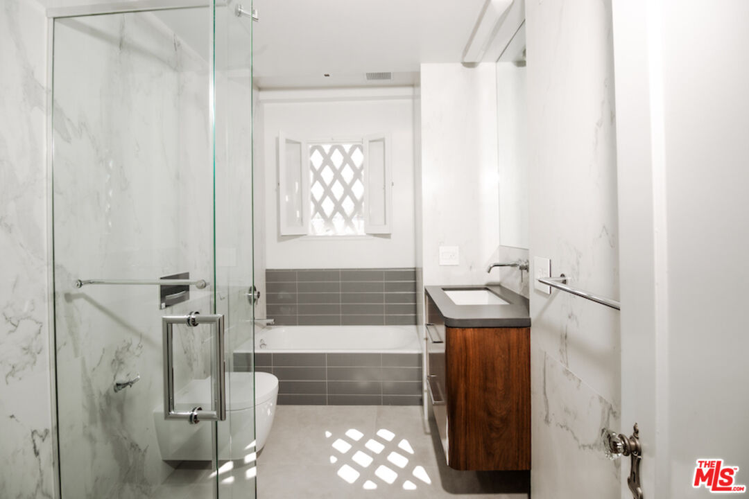 1302 North Sweetzer Avenue, Unit 402 West Hollywood, CA 90069 - Photo 11 of 23 a bathroom with a granite countertop sink a toilet and shower
