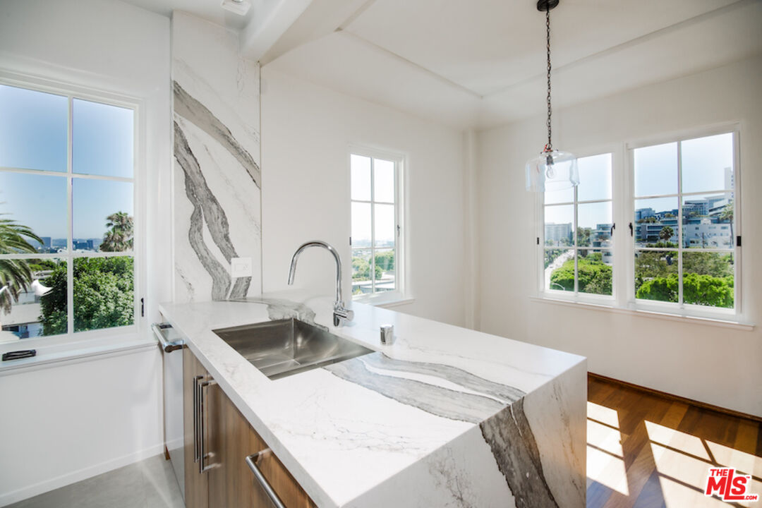 1302 North Sweetzer Avenue, Unit 402 West Hollywood, CA 90069 - Photo 5 of 23 a kitchen that has a sink a stove and a wooden floor