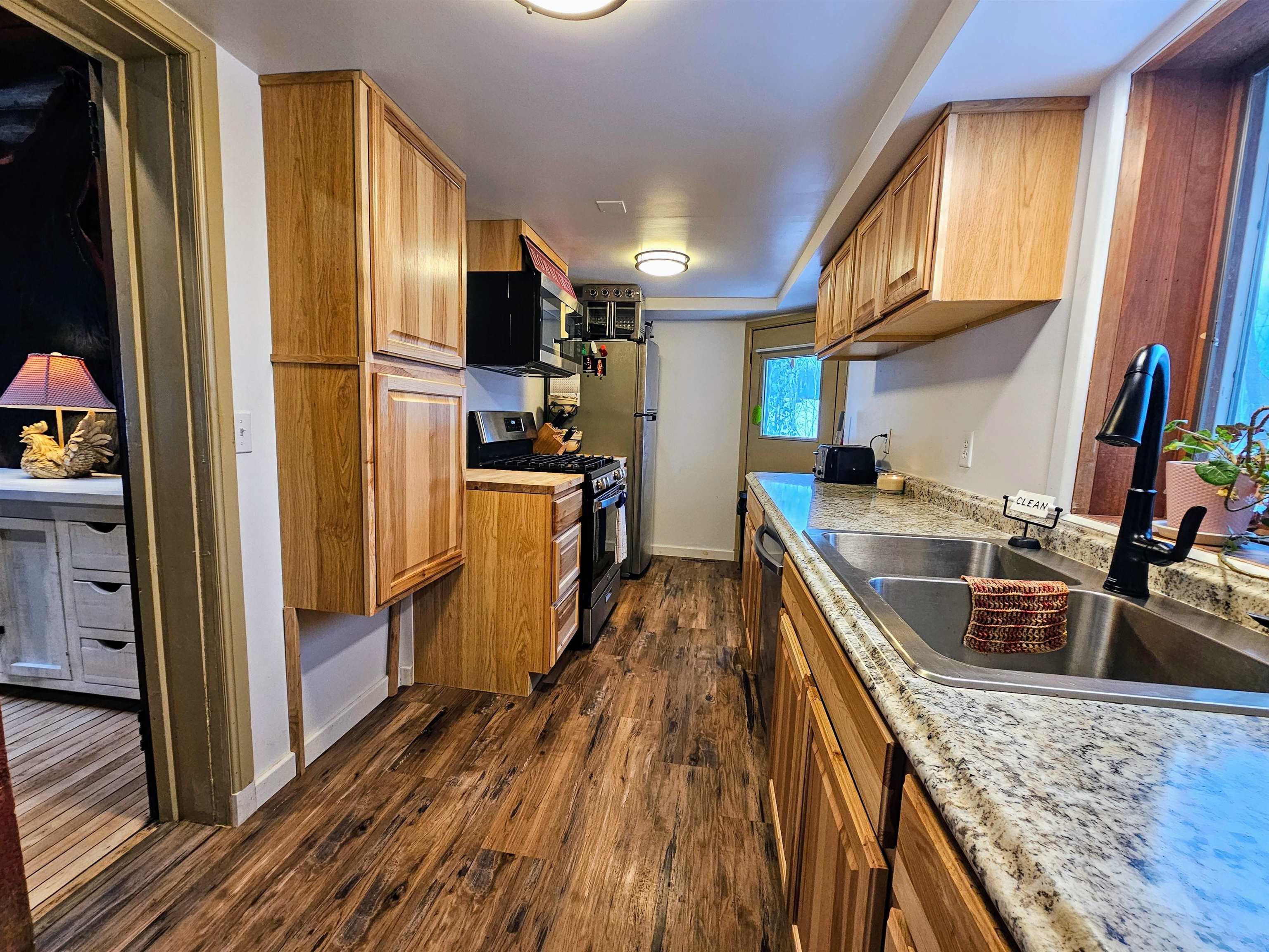 13770 State Highway 13 Herbster, WI 54844 - Photo 6 of 13 Kitchen with appliances with stainless steel finishes, brown cabinetry, and dark wood-style floors