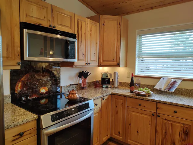a kitchen with stainless steel appliances granite countertop a stove microwave and cabinets