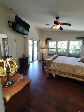 a bedroom with a bed and a flat tv screen on dresser