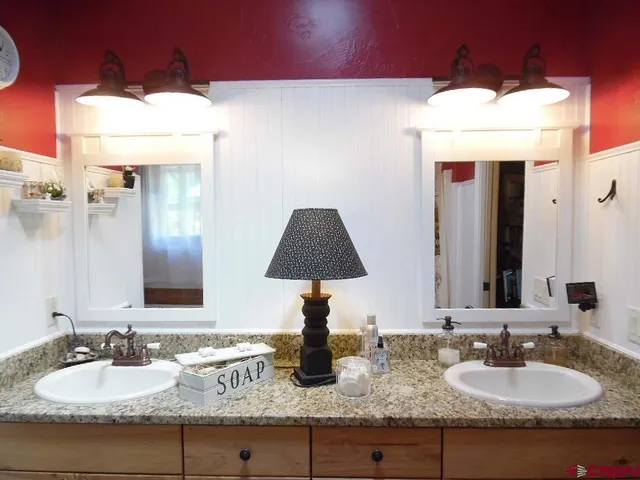 a bathroom with a granite countertop sink and a large mirror