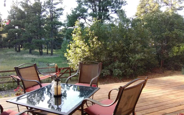 a view of a wooden chairs and table in backyard