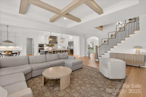 a living room with furniture and a view of kitchen