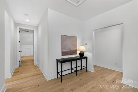 a view of a hallway with wooden floor and staircase