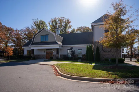a view of a house with a yard and large tree
