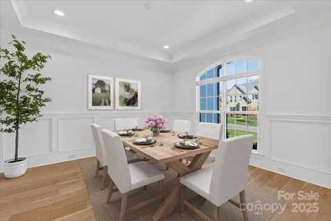 a dining room with furniture potted plants and wooden floor