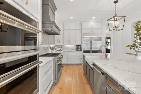a large kitchen with stainless steel appliances granite countertop a stove and a kitchen island