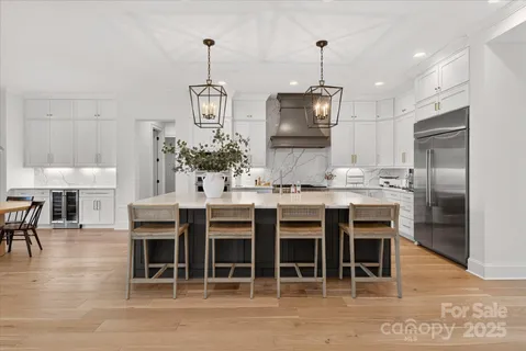 a kitchen with stainless steel appliances kitchen island granite countertop a table and chairs in it