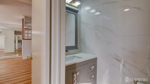 a bathroom with a granite countertop sink and a mirror