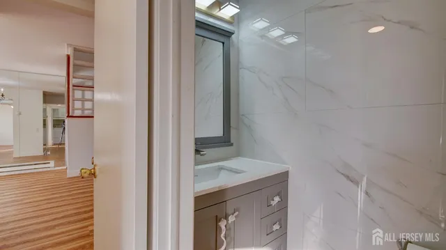 a bathroom with a granite countertop sink and a mirror