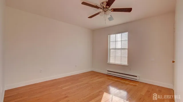 an empty room with a window and a fan