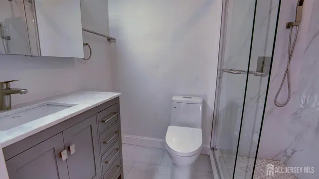 a bathroom with a sink a toilet and shower
