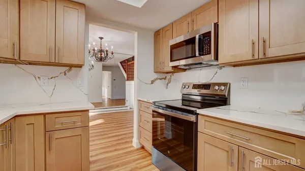 a kitchen with stainless steel appliances granite countertop a sink a stove and microwave