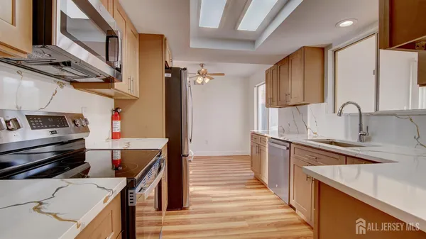 a kitchen with stainless steel appliances a stove a sink and a refrigerator
