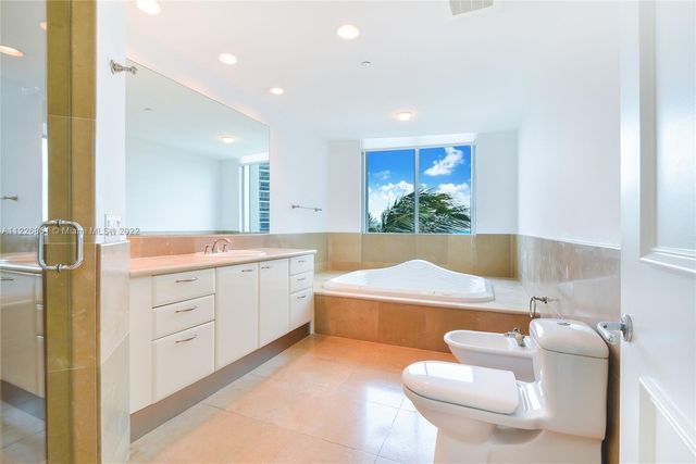 a bathroom with a tub sink and mirror