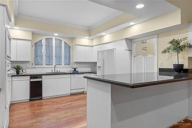 a kitchen with a refrigerator and white cabinets