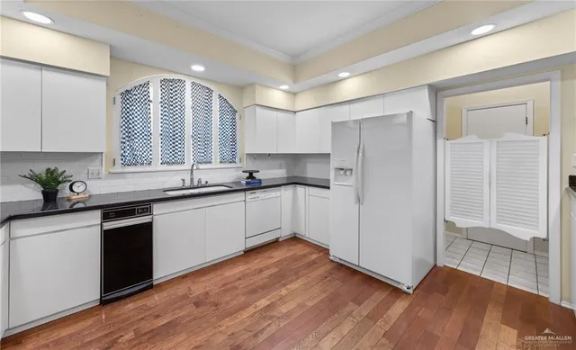 a kitchen with granite countertop white cabinets and white appliances
