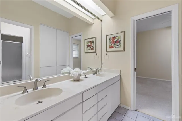 a bathroom with a granite countertop double vanity sink and a mirror