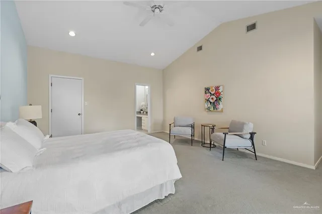 a spacious bedroom with a bed and a chandelier