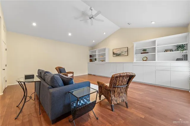 a living room with furniture and a dining table with wooden floor