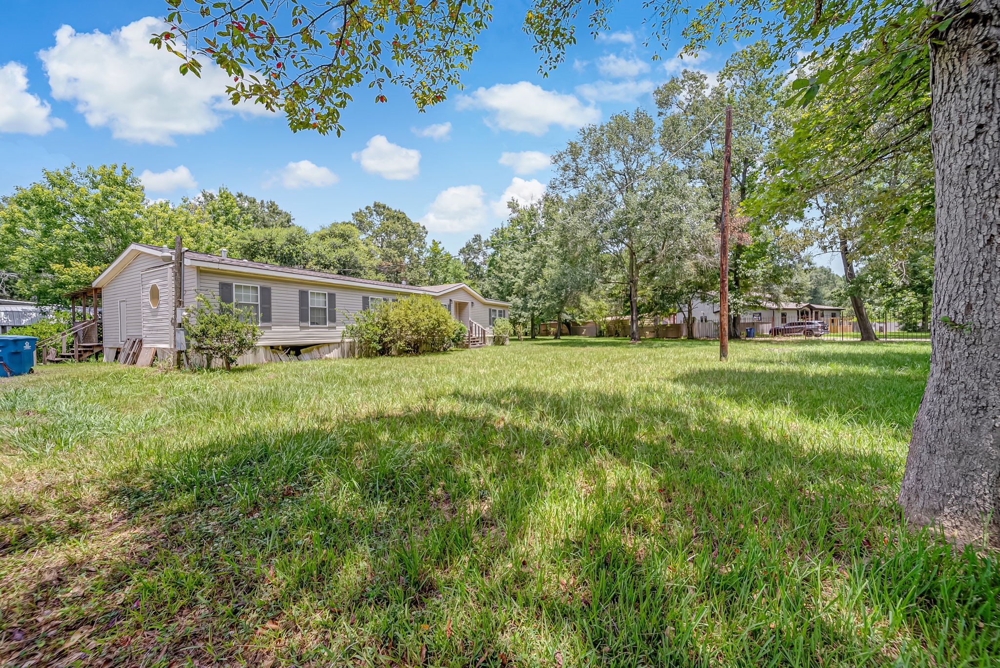 25979 Shade Tree Lane Splendora, TX 77372 - Photo 8 of 22 Framed by mature trees and expansive green space creating a peaceful setting with endless opportunities to personalize and make it your own.