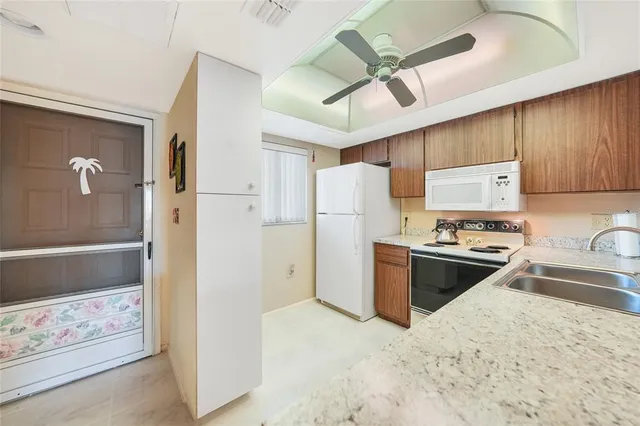 a kitchen with stainless steel appliances granite countertop a refrigerator a sink and a stove