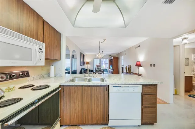 a kitchen with stainless steel appliances granite countertop a sink refrigerator and cabinets